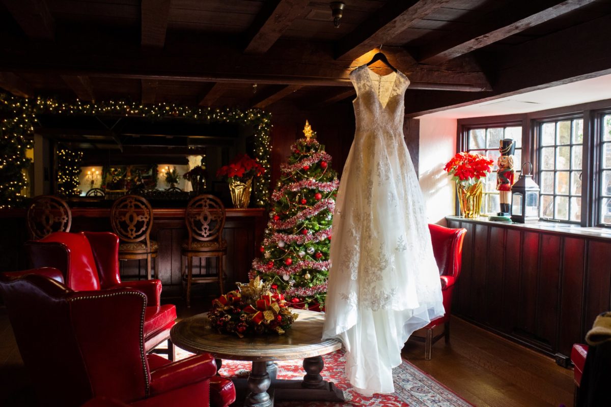 wedding dress hanging from ceiling in lobby around holiday decor