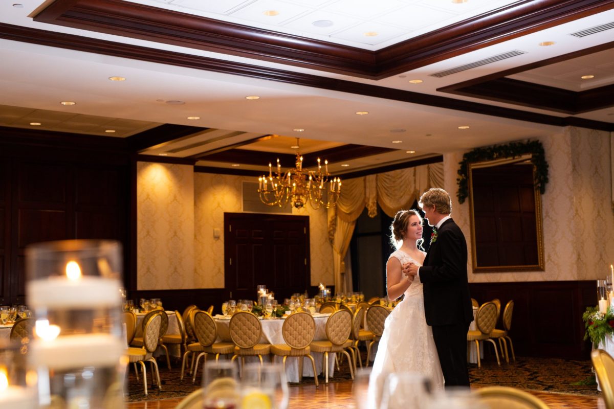 bride and groom slow dancing on ballroom dance floor