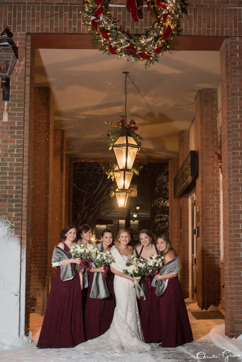 bride and bridesmaids posing together under hotel lobby overhang