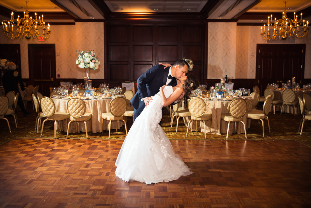 groom dipping and kissing bride on the ballroom dancefloor