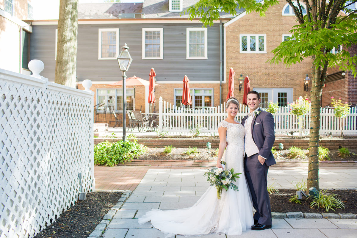 bride and groom posing on back terrace of Nassau Inn