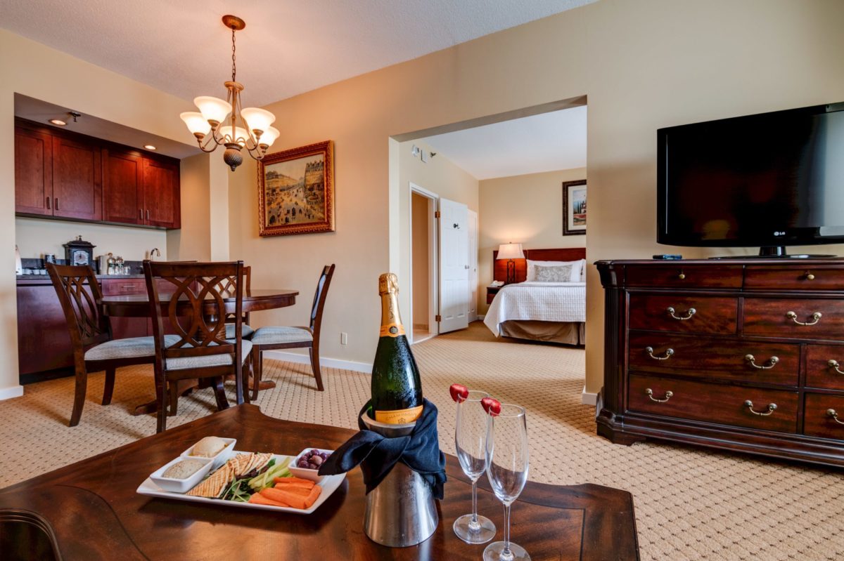 hotel room suite with plate of hummus, chilled champagne and two champagne glasses on table