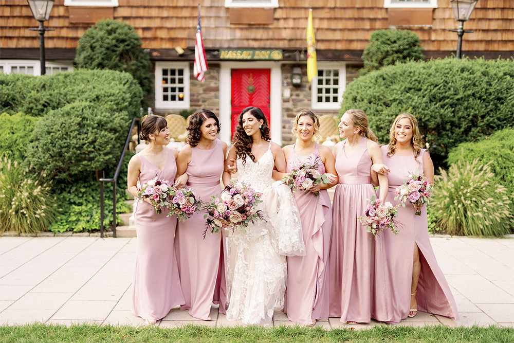 bride and bridesmaids laughing together in front of Nassau Inn red door