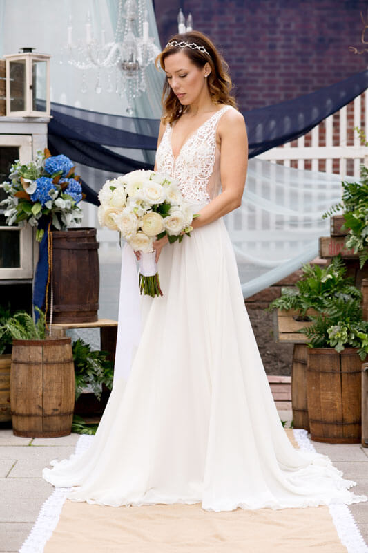 bride posing on terrace with wedding bouquet