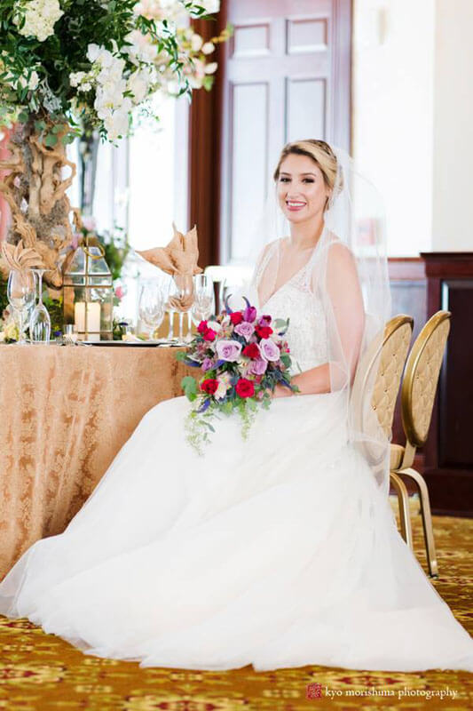 bride sitting at table with flower bouquet