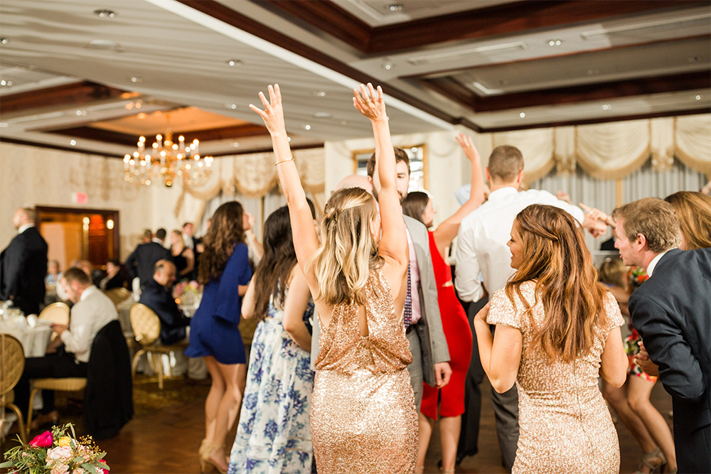 wedding guests dancing with hands up