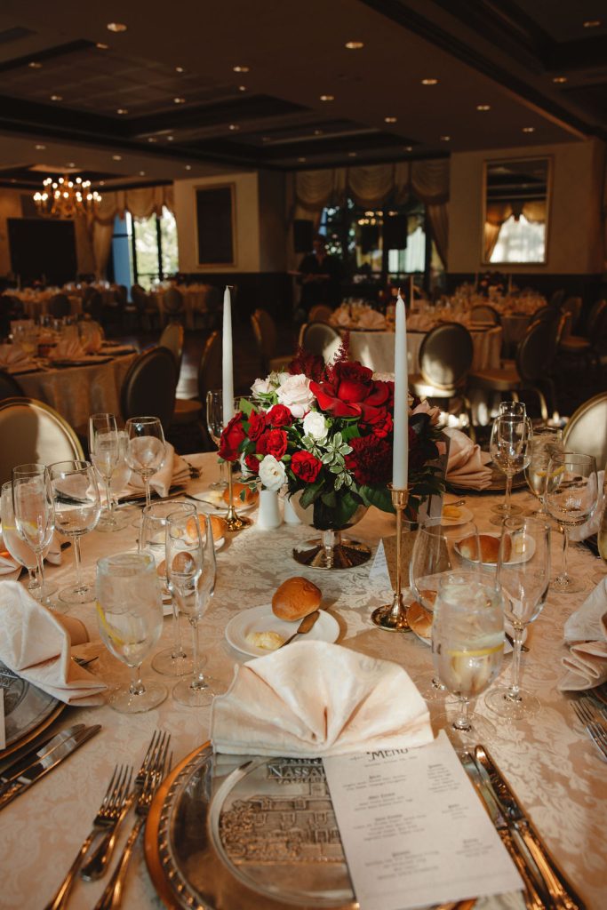 wedding reception table with plates and glasses, candles centered