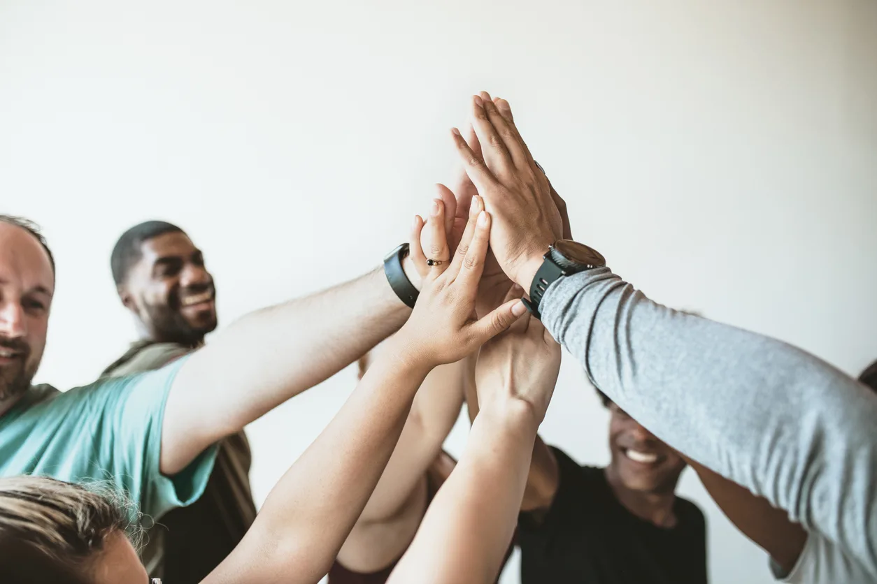 cheerful people doing a group high five