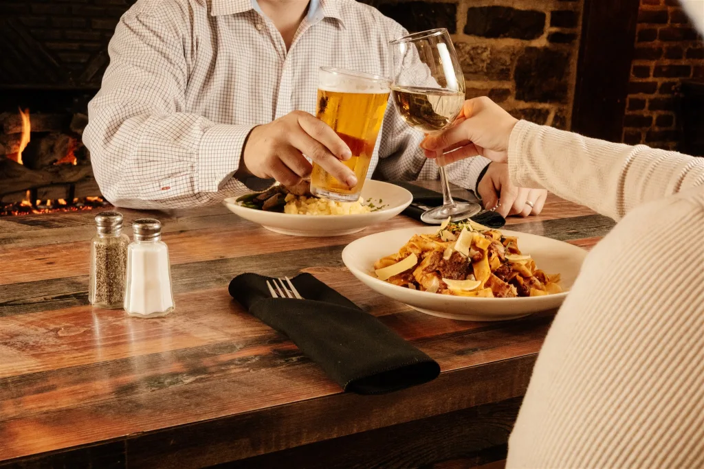 A couple toast over a meal together.